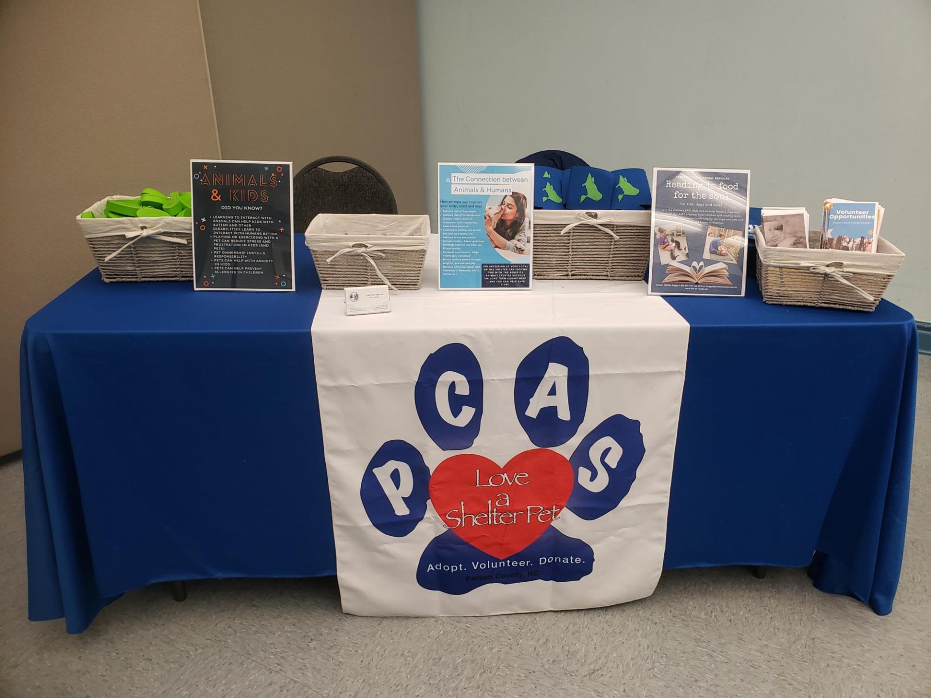 event table with blue tablecloth and PCAS logo
